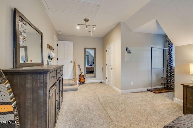 bedroom with light colored carpet, attic access, baseboards, and vaulted ceiling