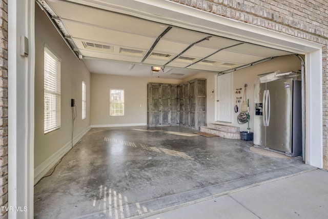 garage featuring stainless steel fridge with ice dispenser, baseboards, and a garage door opener
