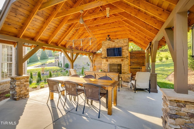 view of patio / terrace featuring an outdoor stone fireplace, a gazebo, and outdoor dining area