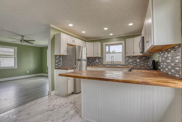 954 Maple St, Kingsport, TN 37660 - kitchen featuring stainless steel appliances, butcher block countertops, a peninsula, tasteful backsplash, and a textured ceiling