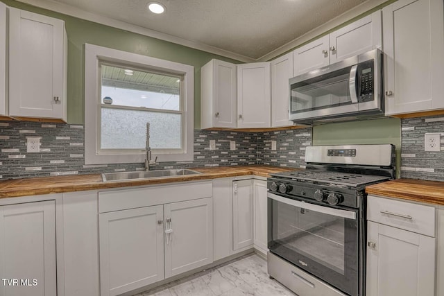 954 Maple St, Kingsport, TN 37660 - kitchen featuring butcher block counters, stainless steel appliances, light marble finish flooring, white cabinets, and decorative backsplash