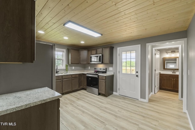 kitchen featuring wood ceiling, appliances with stainless steel finishes, light wood-type flooring, a sink, and light countertops