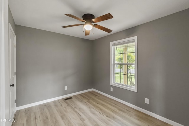 unfurnished room with baseboards, a ceiling fan, light wood finished floors, and visible vents