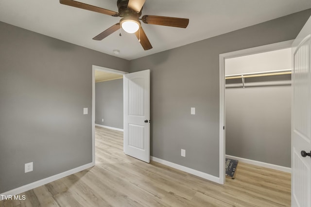 unfurnished bedroom featuring light wood-type flooring, baseboards, ceiling fan, and a closet