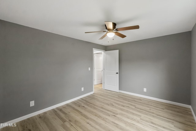 empty room featuring ceiling fan, baseboards, and light wood-style flooring