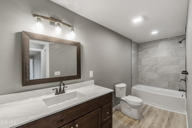 bathroom featuring vanity, wood finished floors, toilet, washtub / shower combination, and recessed lighting