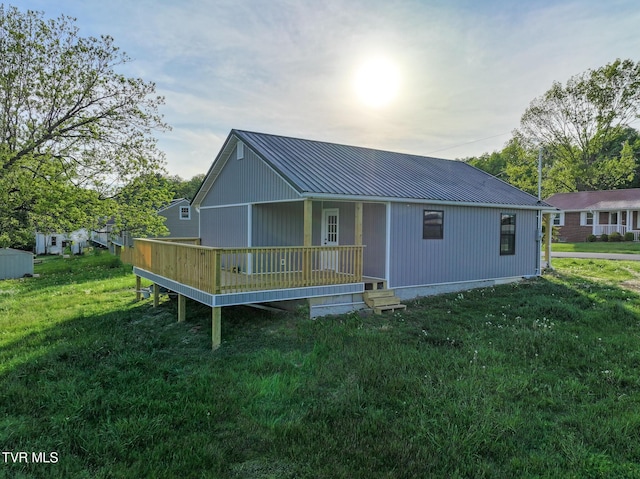 back of house with a lawn, a porch, and metal roof