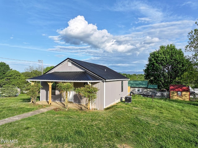 exterior space featuring a yard, central AC, and metal roof