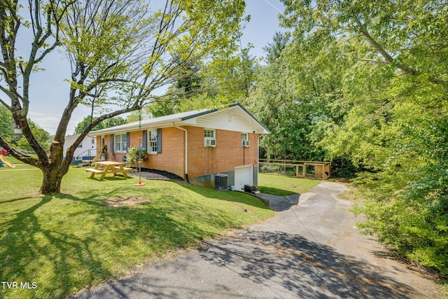 view of property exterior featuring a garage, a lawn, driveway, and brick siding