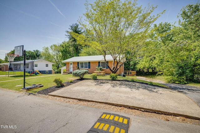 ranch-style home featuring brick siding and a front yard