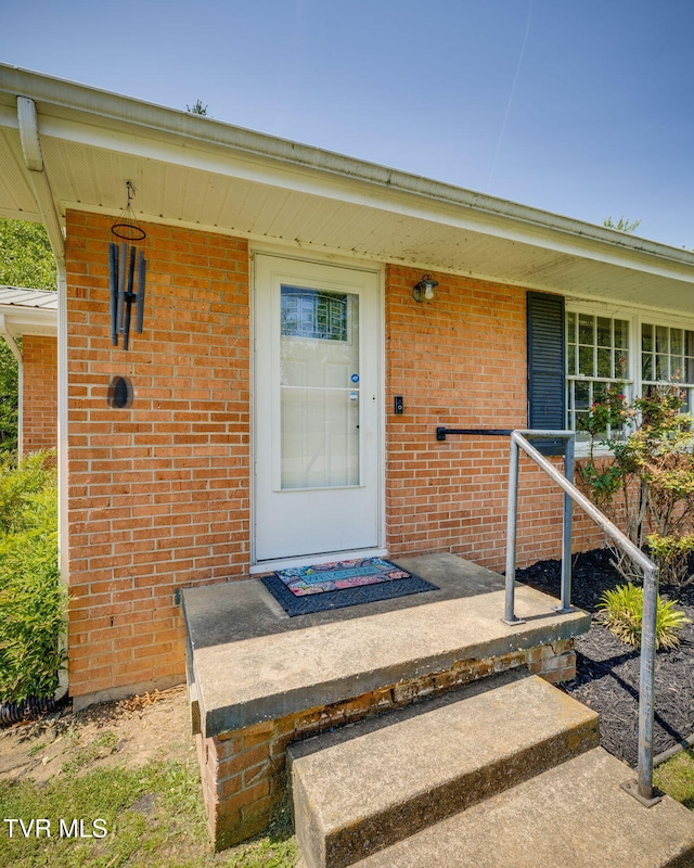 view of exterior entry featuring brick siding