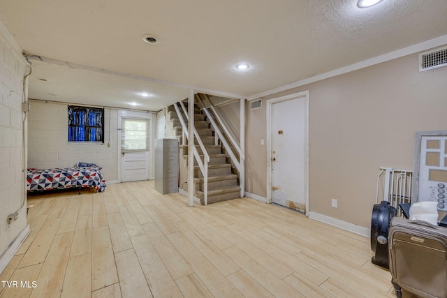 basement featuring visible vents, wood finished floors, and stairway