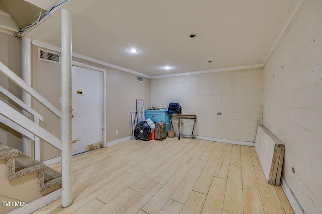 interior space with crown molding, radiator heating unit, visible vents, and wood finished floors