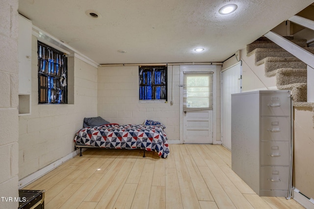 bedroom with recessed lighting, a textured ceiling, and wood finished floors