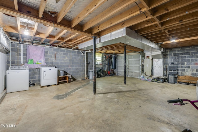 unfinished below grade area featuring separate washer and dryer, concrete block wall, and water heater