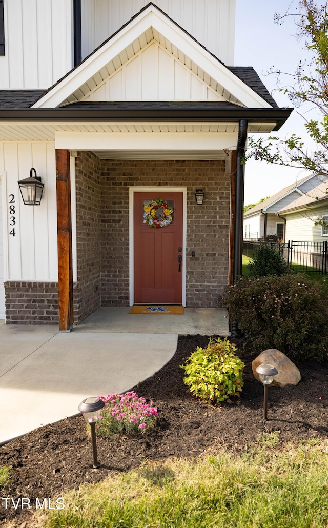 2834 Mccoy St, Kingsport, TN 37664 - doorway to property with fence, board and batten siding, a porch, and brick siding
