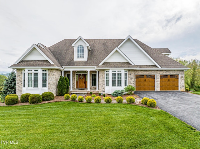 view of front of house with driveway, a front yard, roof with shingles, brick siding, and an attached garage