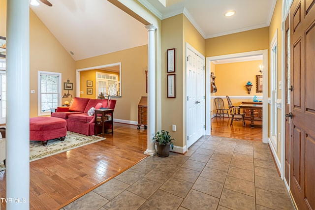 entrance foyer with ornamental molding, wood finished floors, baseboards, ceiling fan, and ornate columns