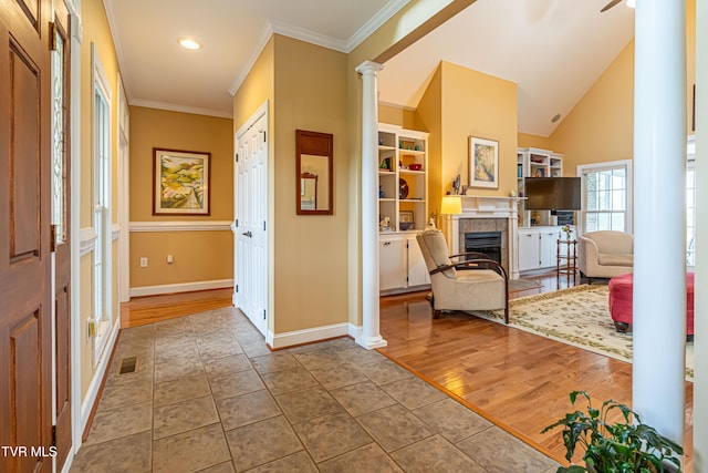 tiled foyer with decorative columns, visible vents, a fireplace, baseboards, and ornamental molding