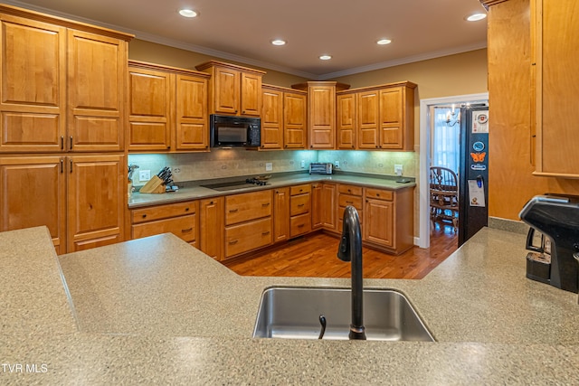 kitchen featuring crown molding, recessed lighting, a sink, and black appliances