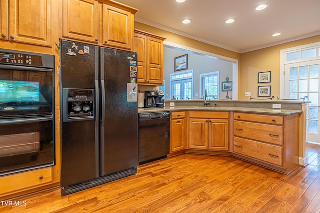 kitchen featuring crown molding, light wood-type flooring, a sink, black appliances, and recessed lighting