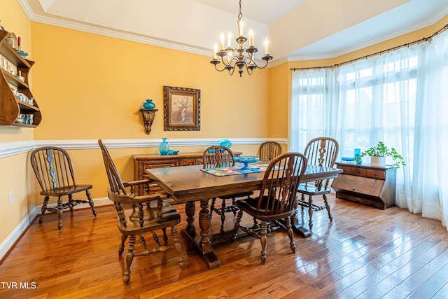 dining room featuring an inviting chandelier, crown molding, and wood-type flooring