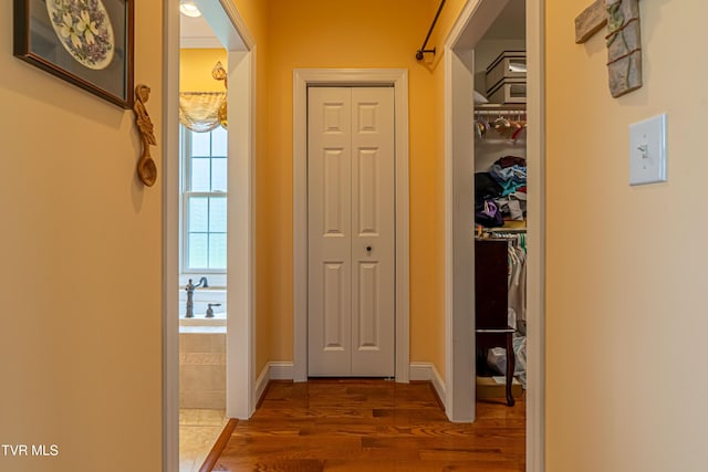hallway featuring baseboards and dark wood-style floors