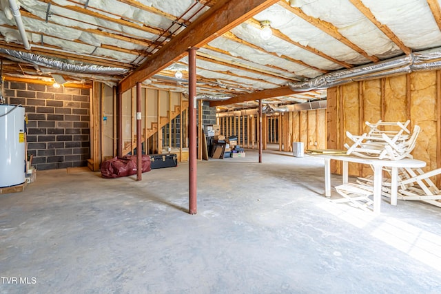 unfinished basement featuring stairs and water heater