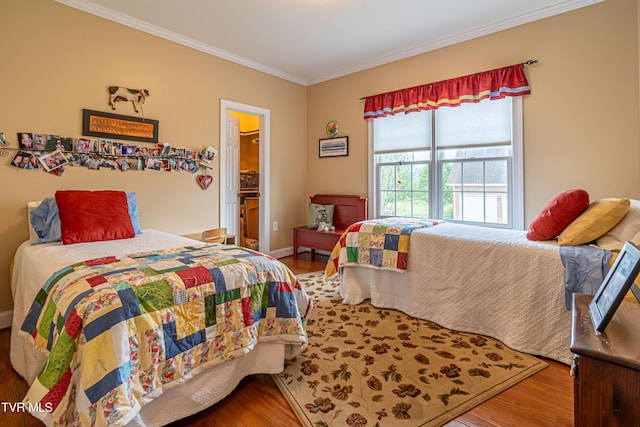 bedroom with ornamental molding and wood finished floors