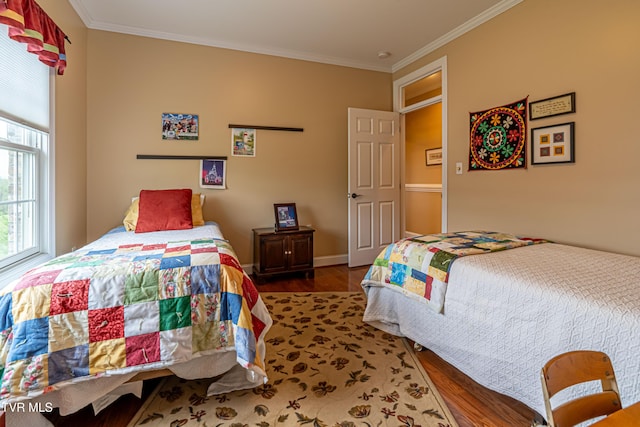 bedroom featuring crown molding, baseboards, and wood finished floors