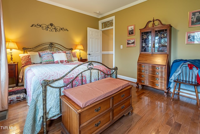 bedroom featuring baseboards, ornamental molding, and hardwood / wood-style floors