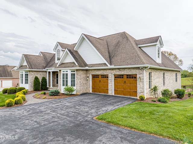 view of front of property featuring brick siding, a garage, aphalt driveway, and a front yard