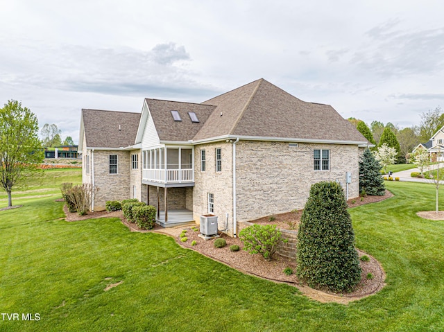 view of home's exterior with a yard, stone siding, a shingled roof, and a sunroom