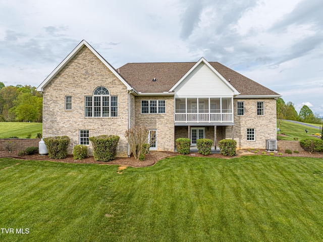 back of house with a sunroom, a shingled roof, and a yard