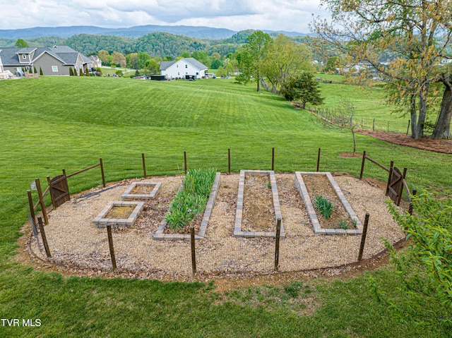 exterior space featuring a garden, fence, a yard, and a mountain view