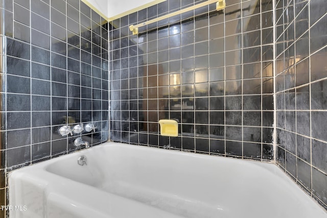 bathroom with tile walls and a bathtub
