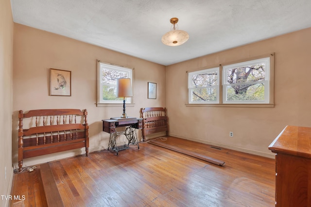 bedroom featuring wood-type flooring and baseboards