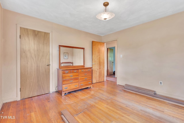 spare room with baseboards and wood finished floors