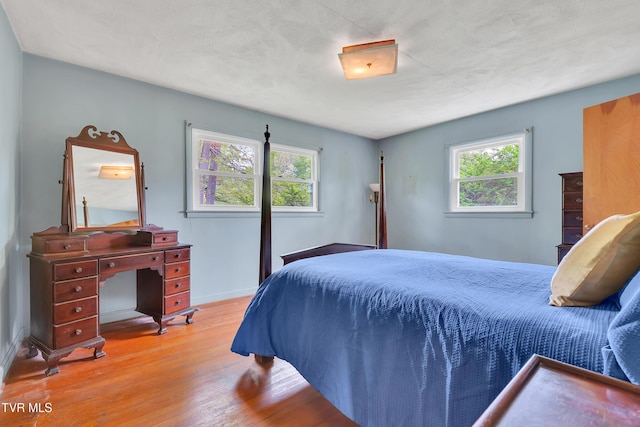 bedroom with baseboards and wood finished floors