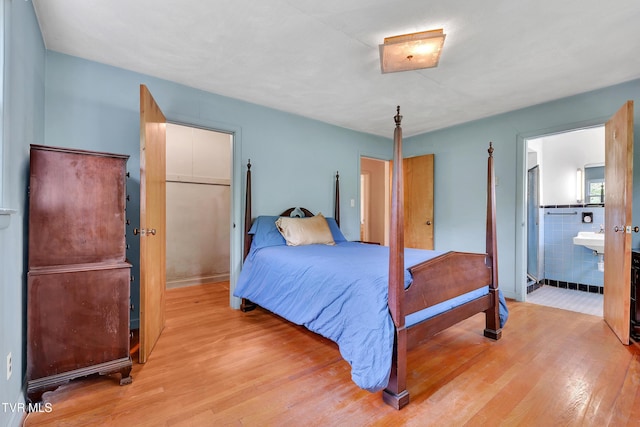 bedroom featuring connected bathroom and wood finished floors