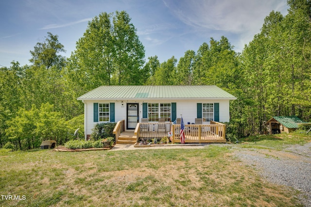 ranch-style house with a storage shed, an outbuilding, a front lawn, and metal roof