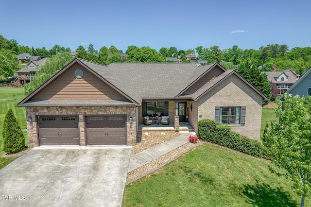 view of front of property with concrete driveway, a porch, an attached garage, and a front yard