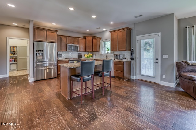 kitchen with backsplash, dark wood-style flooring, appliances with stainless steel finishes, and visible vents