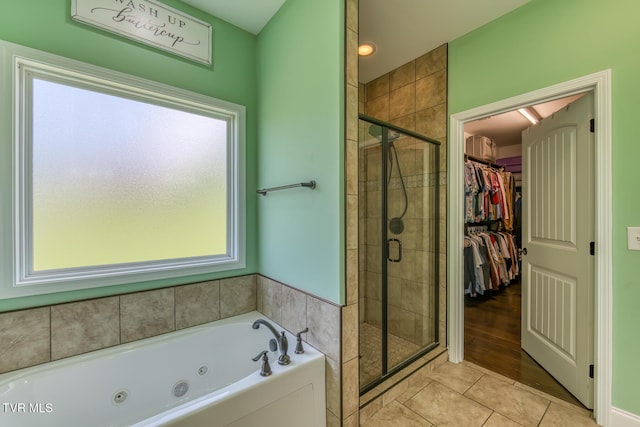bathroom with a whirlpool tub, tile patterned floors, a shower stall, and a walk in closet