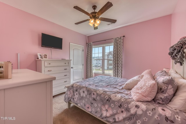 bedroom featuring visible vents, a ceiling fan, and light colored carpet