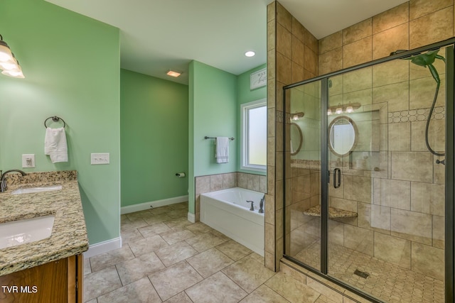 bathroom featuring baseboards, a sink, a garden tub, and a shower stall