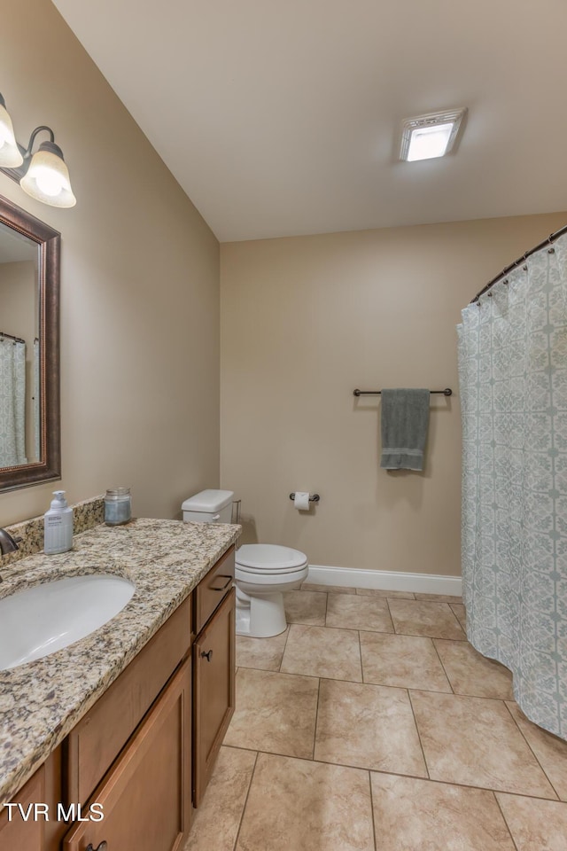 bathroom featuring toilet, baseboards, tile patterned flooring, and vanity