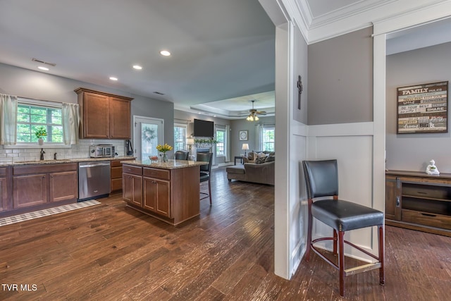 kitchen with open floor plan, a breakfast bar area, a sink, dark wood finished floors, and dishwasher