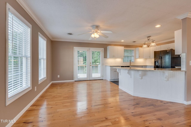 241 Stone Edge Cir, Kingsport, TN 37660 - kitchen with ornamental molding, a peninsula, a kitchen bar, white cabinets, and black fridge