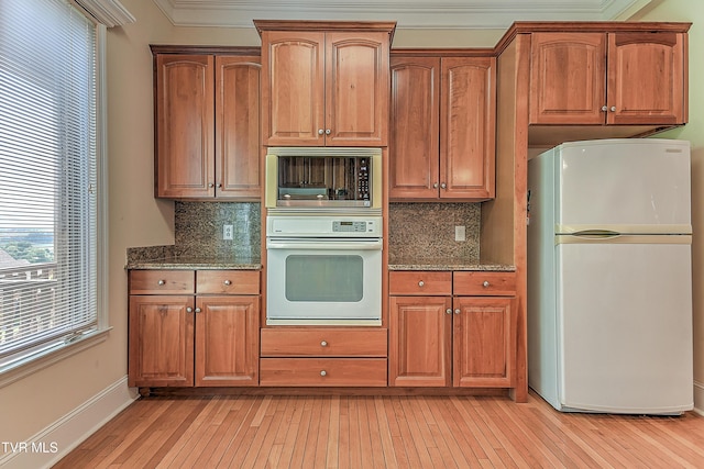2304 Granite Dr, Johnson City, TN 37604 - kitchen featuring light wood-style floors, dark stone counters, decorative backsplash, and white appliances